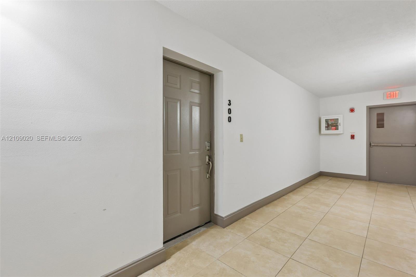 Neutral-toned entry door with six-panel design and ceramic tile flooring throughout