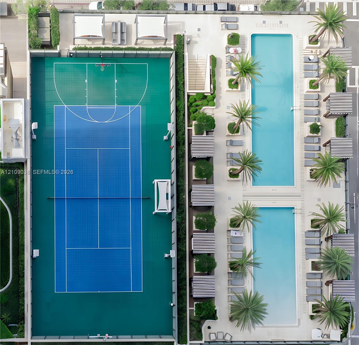 Recreational amenities featuring a multi-sport court with basketball and tennis markings, two rectangular swimming pools, and landscaped areas with palm trees