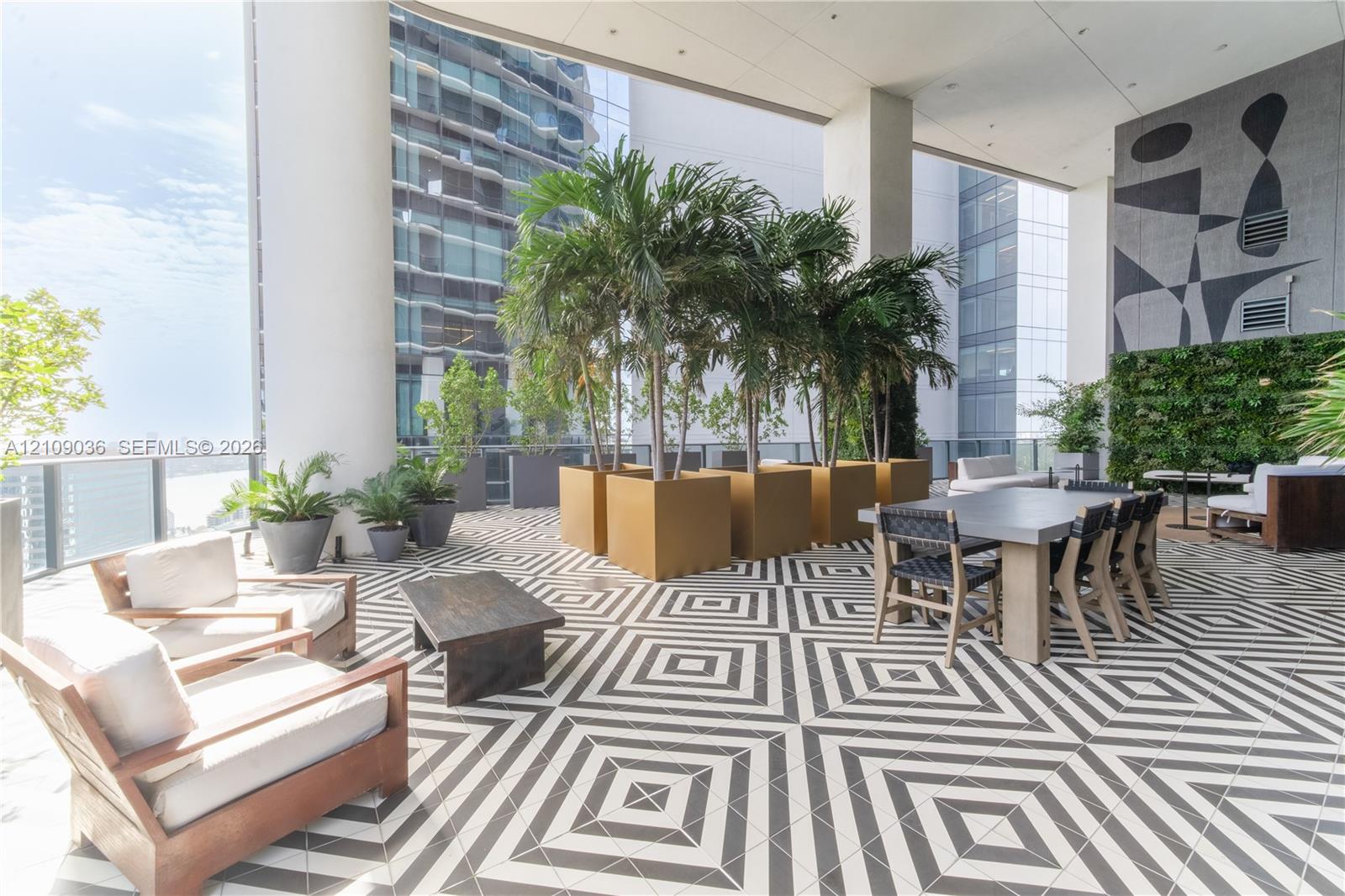 Covered outdoor terrace featuring geometric patterned floor tiling, integrated vertical greenery, and built-in structural columns