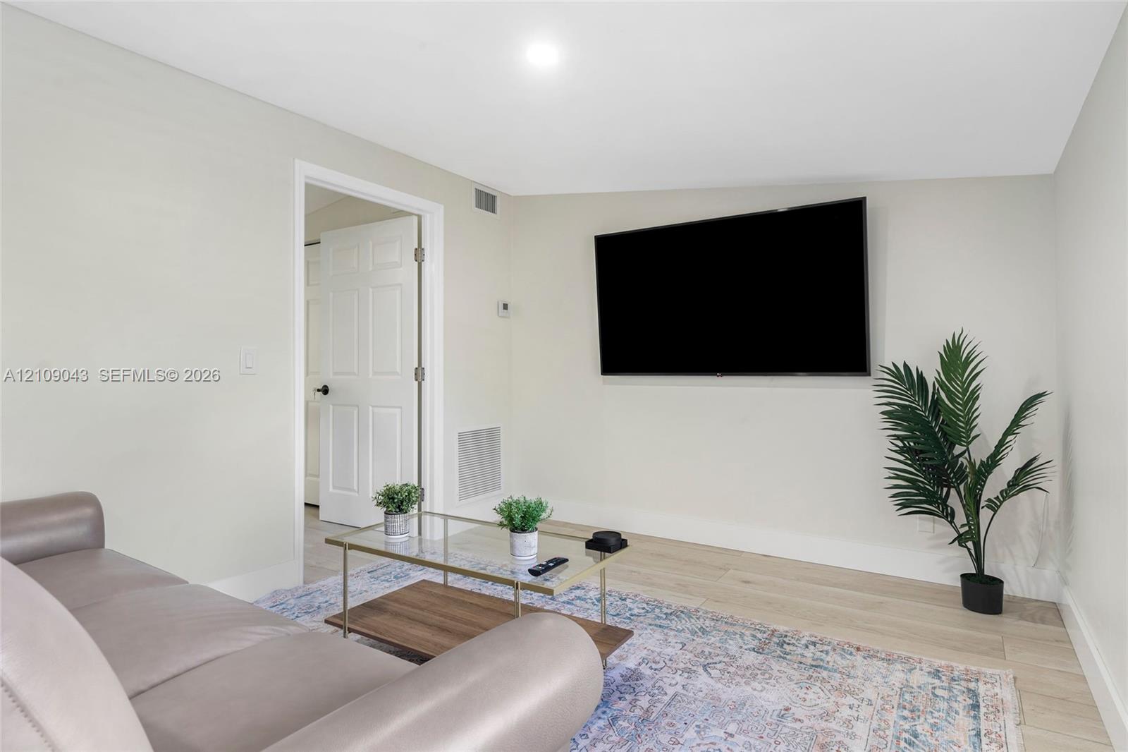 Neutral interior featuring wood-finish flooring, recessed lighting, and a six-panel interior door