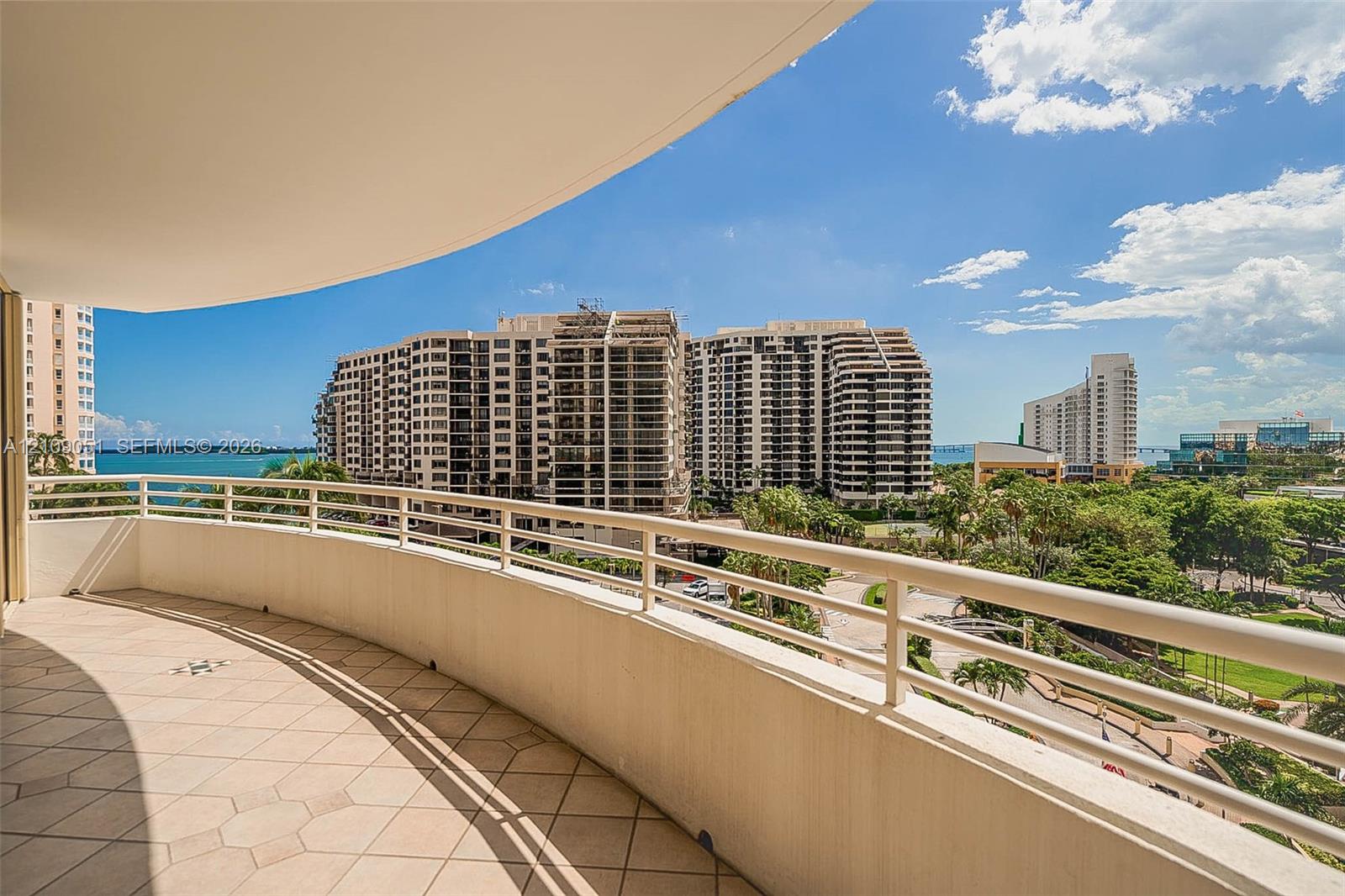 Curved balcony featuring tile flooring and metal railings