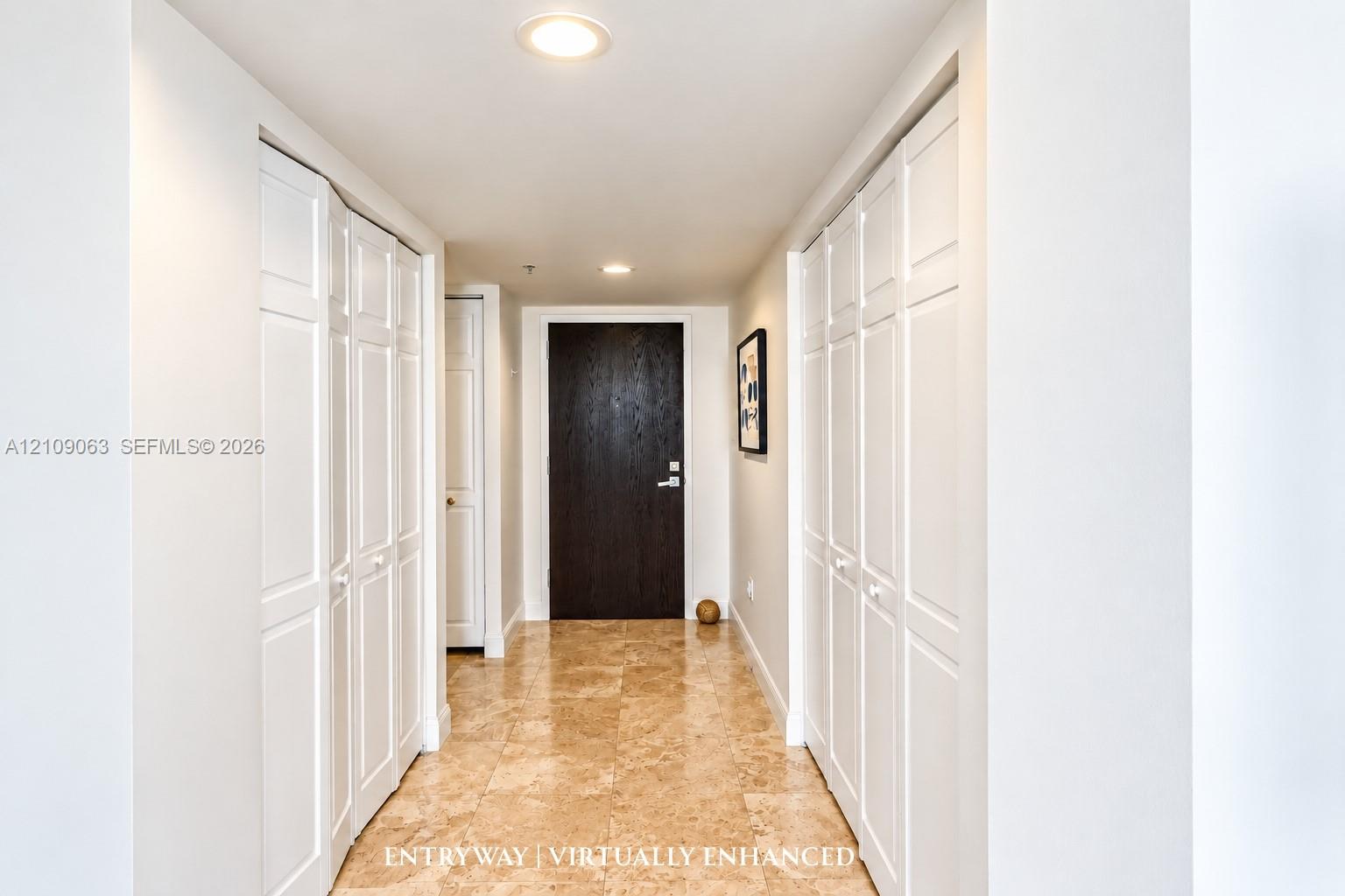 Foyer featuring stone tile flooring, dual floor-to-ceiling bi-fold door closets, recessed lighting, and a dark-finish entrance door