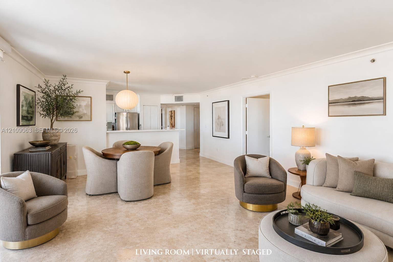 Open-concept interior featuring light stone flooring, crown molding, and a suspended globe pendant light fixture