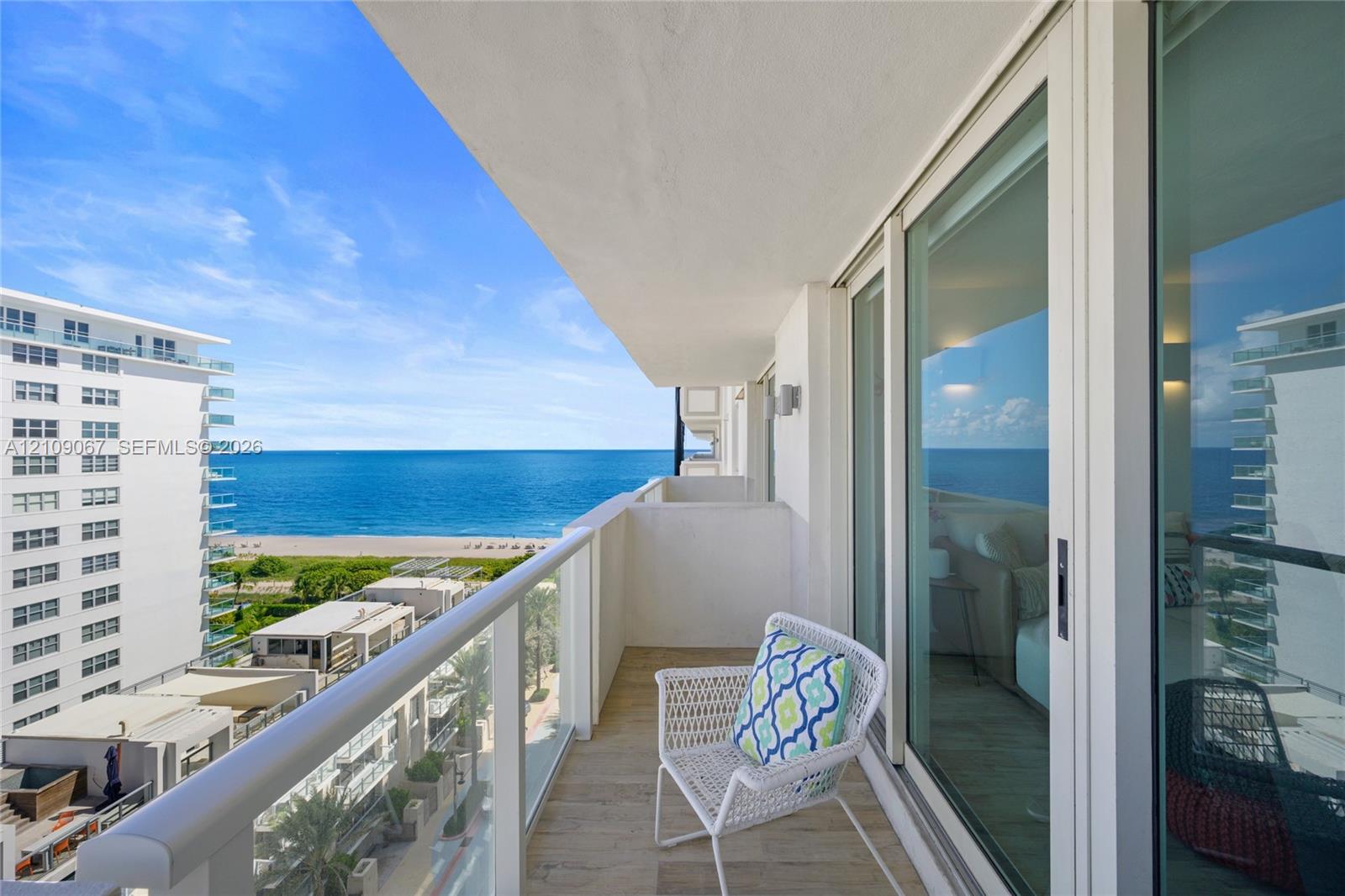 Private balcony featuring tile flooring, a glass-panel railing, and floor-to-ceiling sliding glass doors