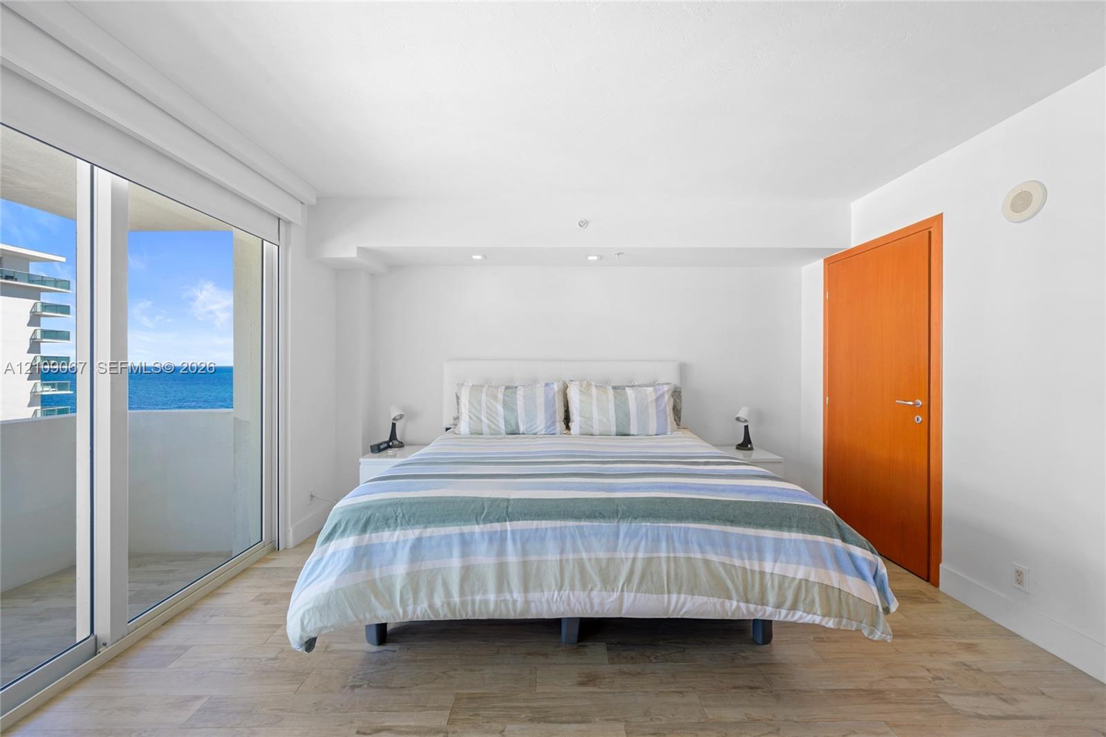 Wood-finish flooring, floor-to-ceiling sliding glass doors, recessed lighting, and a solid wood door Wood-finish flooring, floor-to-ceiling sliding glass doors, recessed lighting, and a solid wood door