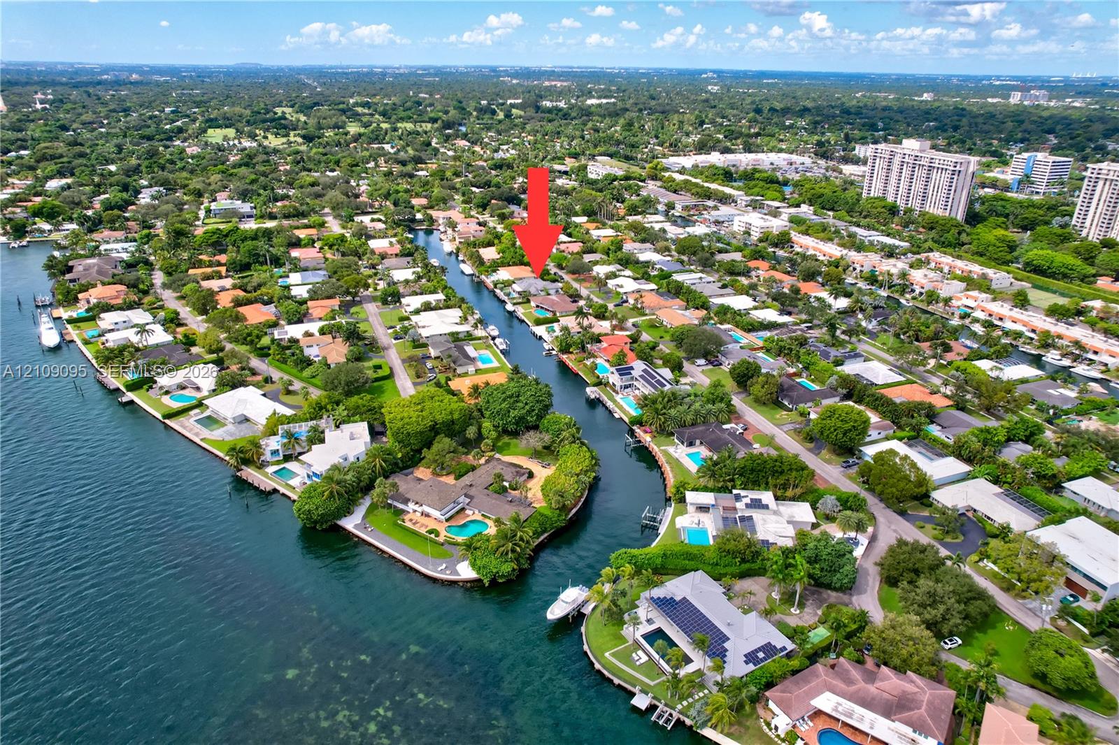 Aerial perspective of a canal-front property featuring direct water access, a private bulkhead, and mature tropical landscaping Aerial perspective of a canal-front property featuring direct water access, a private bulkhead, and mature tropical landscaping