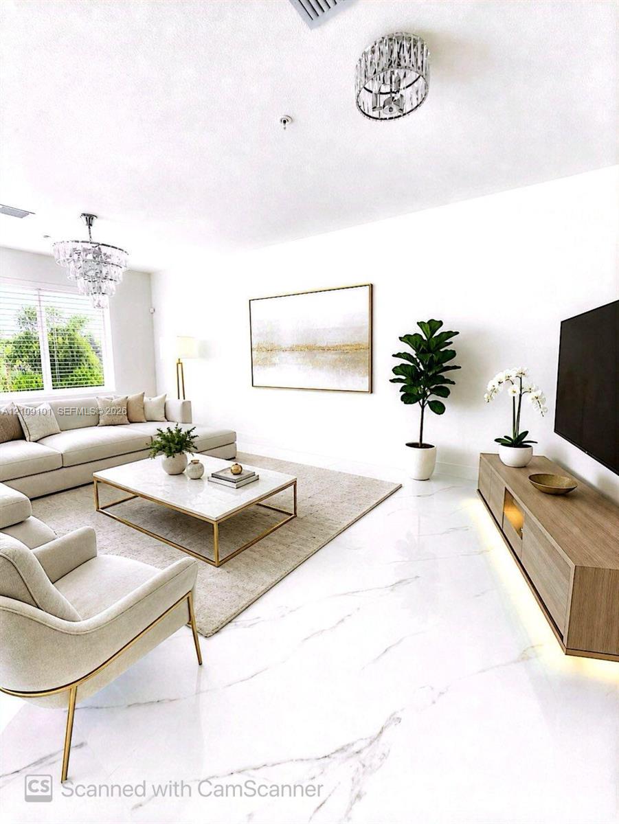 Polished stone-finish flooring, two crystal-accented chandeliers, and a custom built-in wood-finish media console with under-cabinet lighting