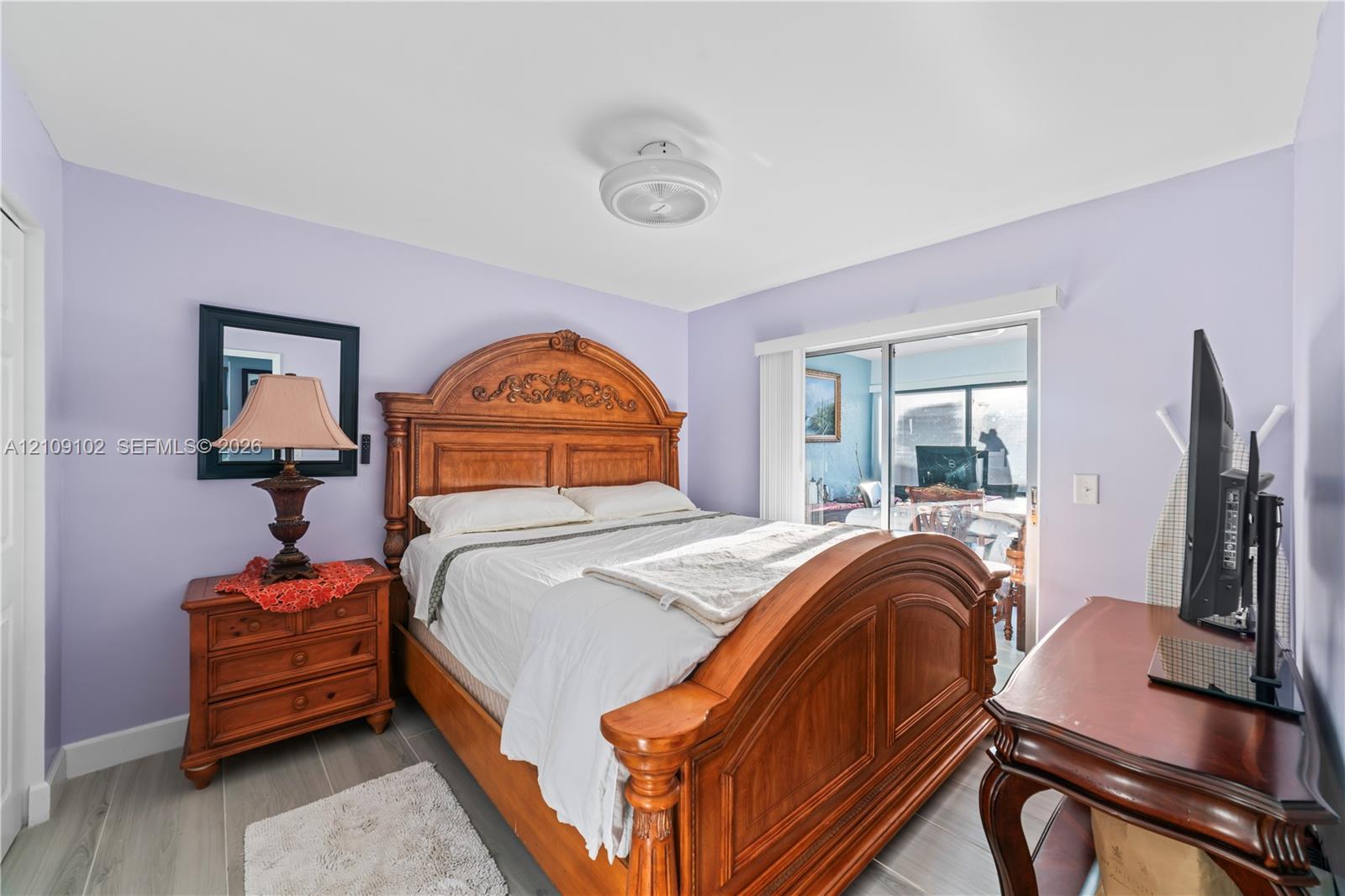 Sliding glass door, wood-finish flooring, and semi-flush mount ceiling fixture