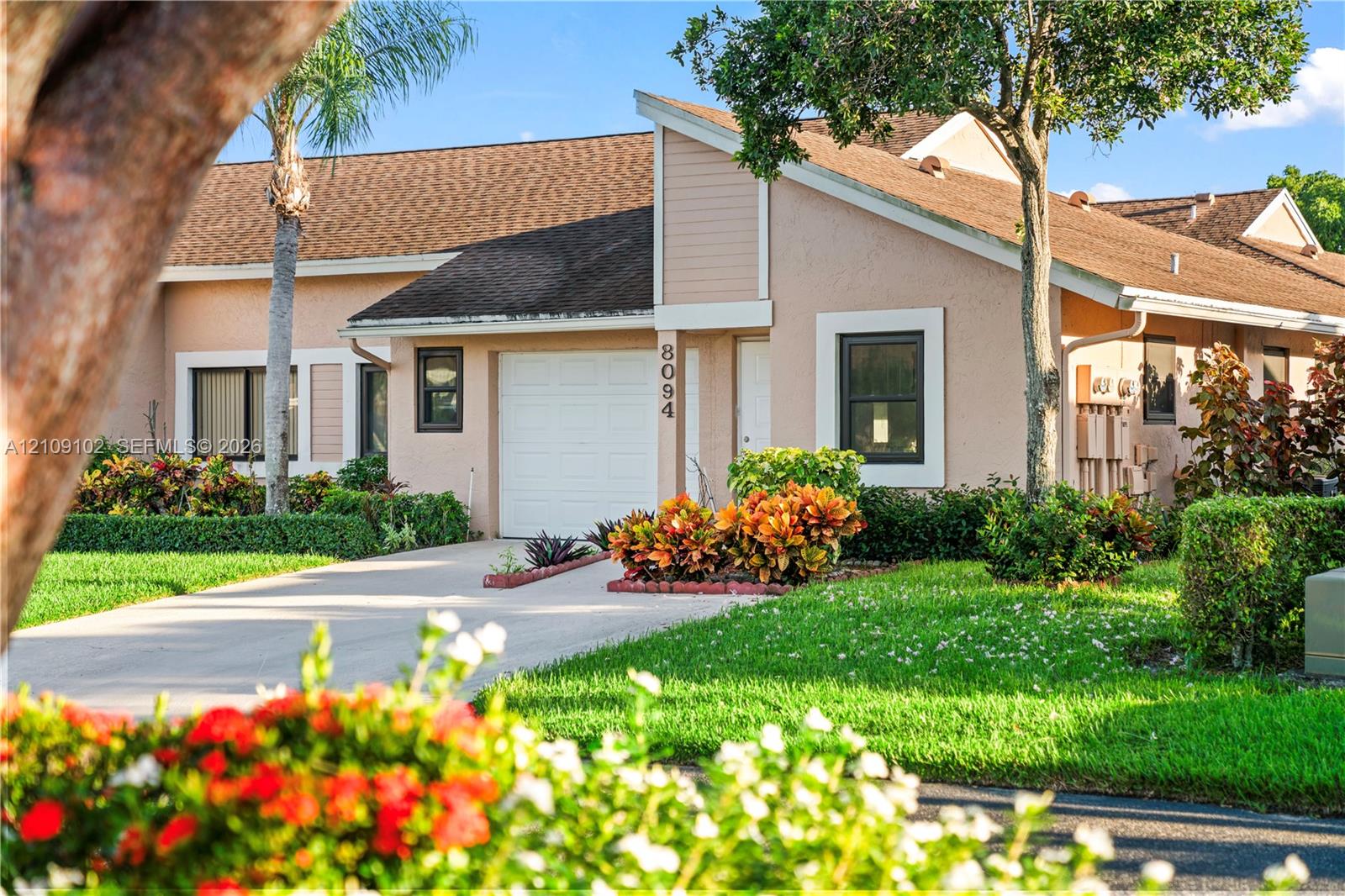 Stucco exterior with a single-car garage, pitched roofline, and landscaped grounds Stucco exterior with a single-car garage, pitched roofline, and landscaped grounds