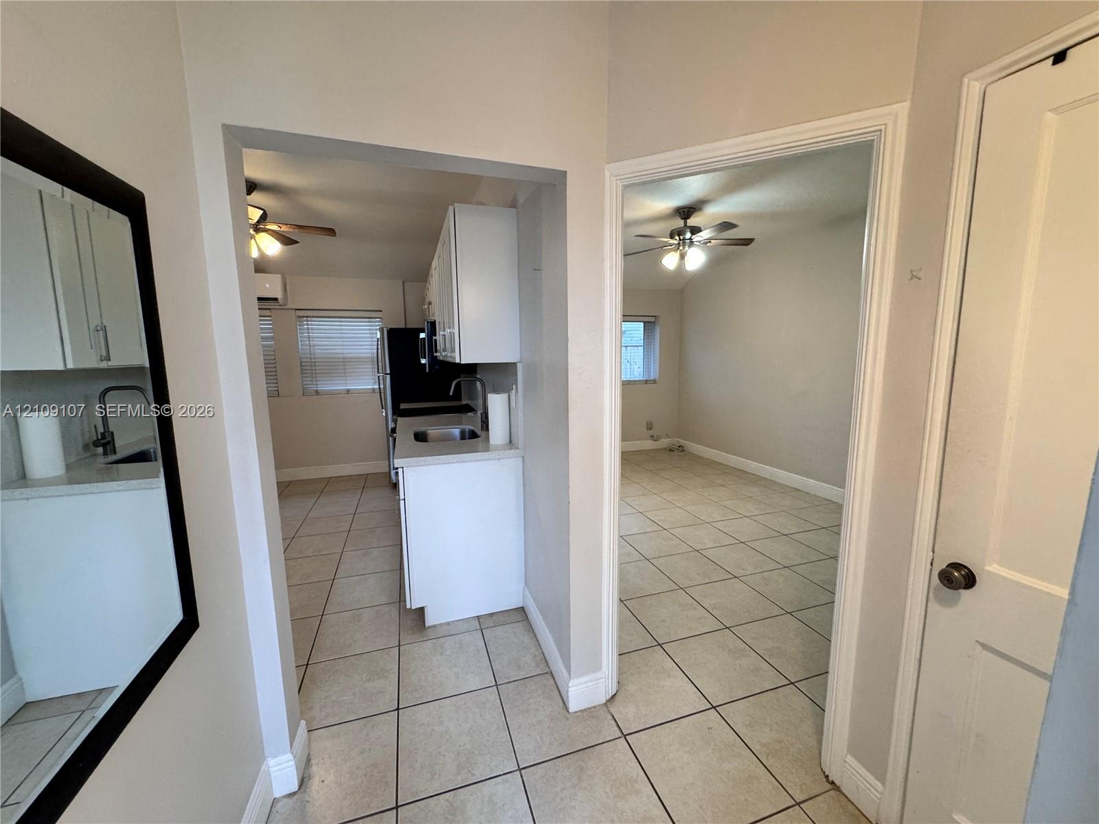 Tile flooring, white cabinetry, solid-surface countertops, and ceiling fans