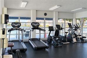 Fitness center featuring floor-to-ceiling windows, rubberized flooring, and built-in wall-mounted soap and sanitizer dispensers