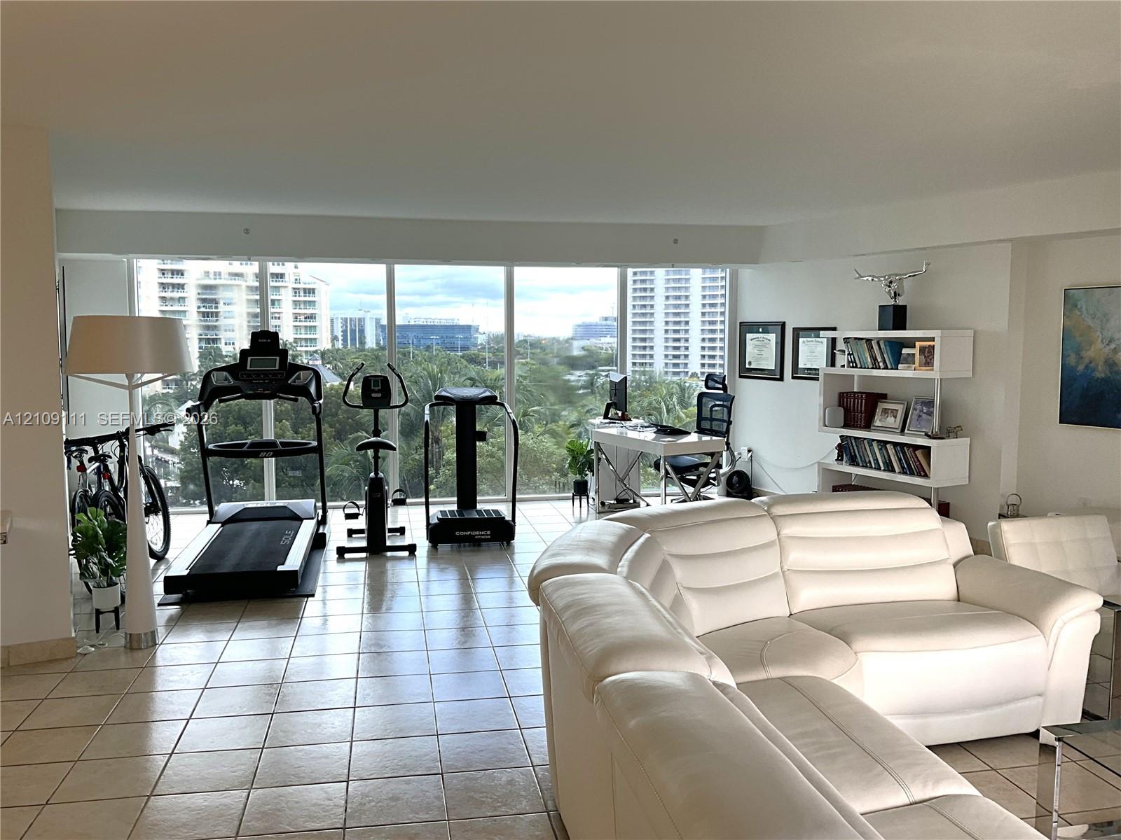 Open-concept interior featuring large-format ceramic tile flooring and expansive floor-to-ceiling windows Open-concept interior featuring large-format ceramic tile flooring and expansive floor-to-ceiling windows