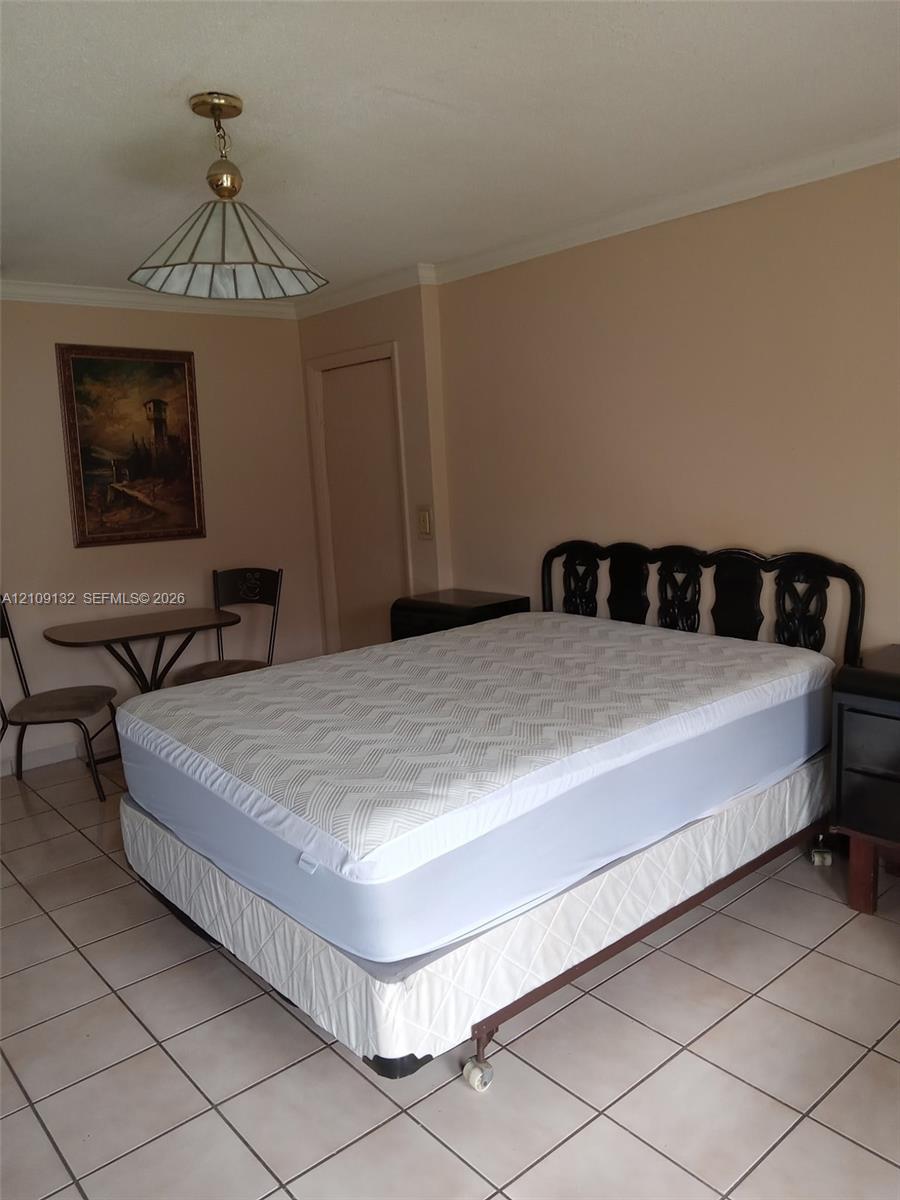 Ceramic tile flooring, crown molding, and geometric pendant lighting