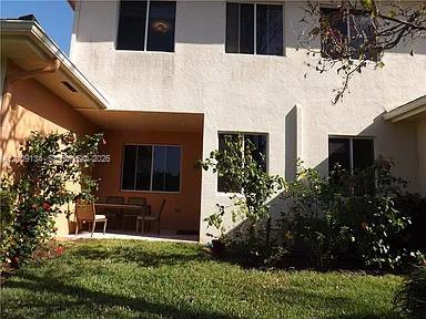 Stucco exterior featuring a covered patio, dual-tone facade, and multiple windows