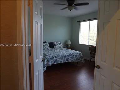 Wood-finish flooring, double-panel interior entry doors, and a ceiling fan with integrated light fixture