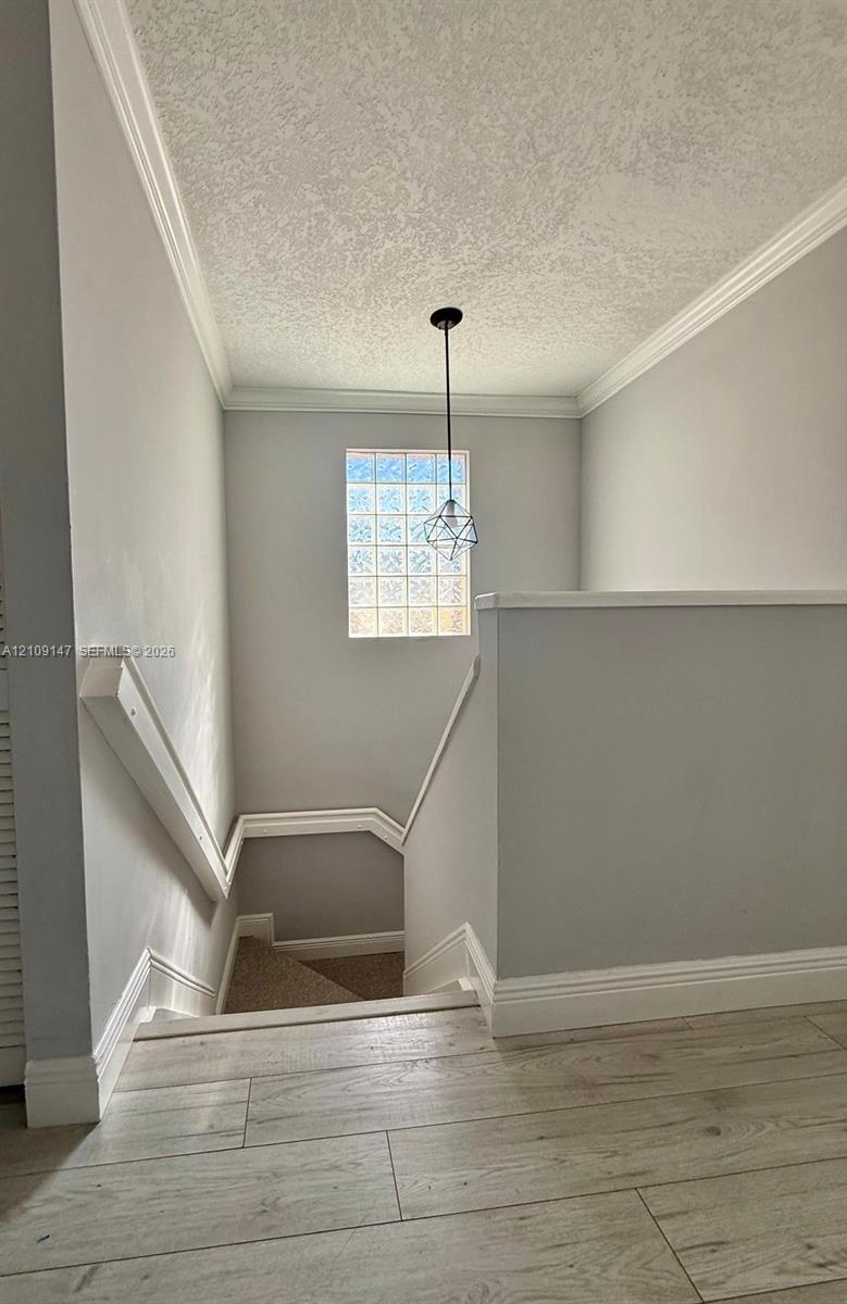 Wood-finish flooring, crown molding, glass block window, and geometric pendant lighting Wood-finish flooring, crown molding, glass block window, and geometric pendant lighting