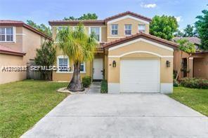 Two-story stucco exterior featuring a tiled roof, arched entryway, and an attached single-car garage with a concrete driveway Two-story stucco exterior featuring a tiled roof, arched entryway, and an attached single-car garage with a concrete driveway