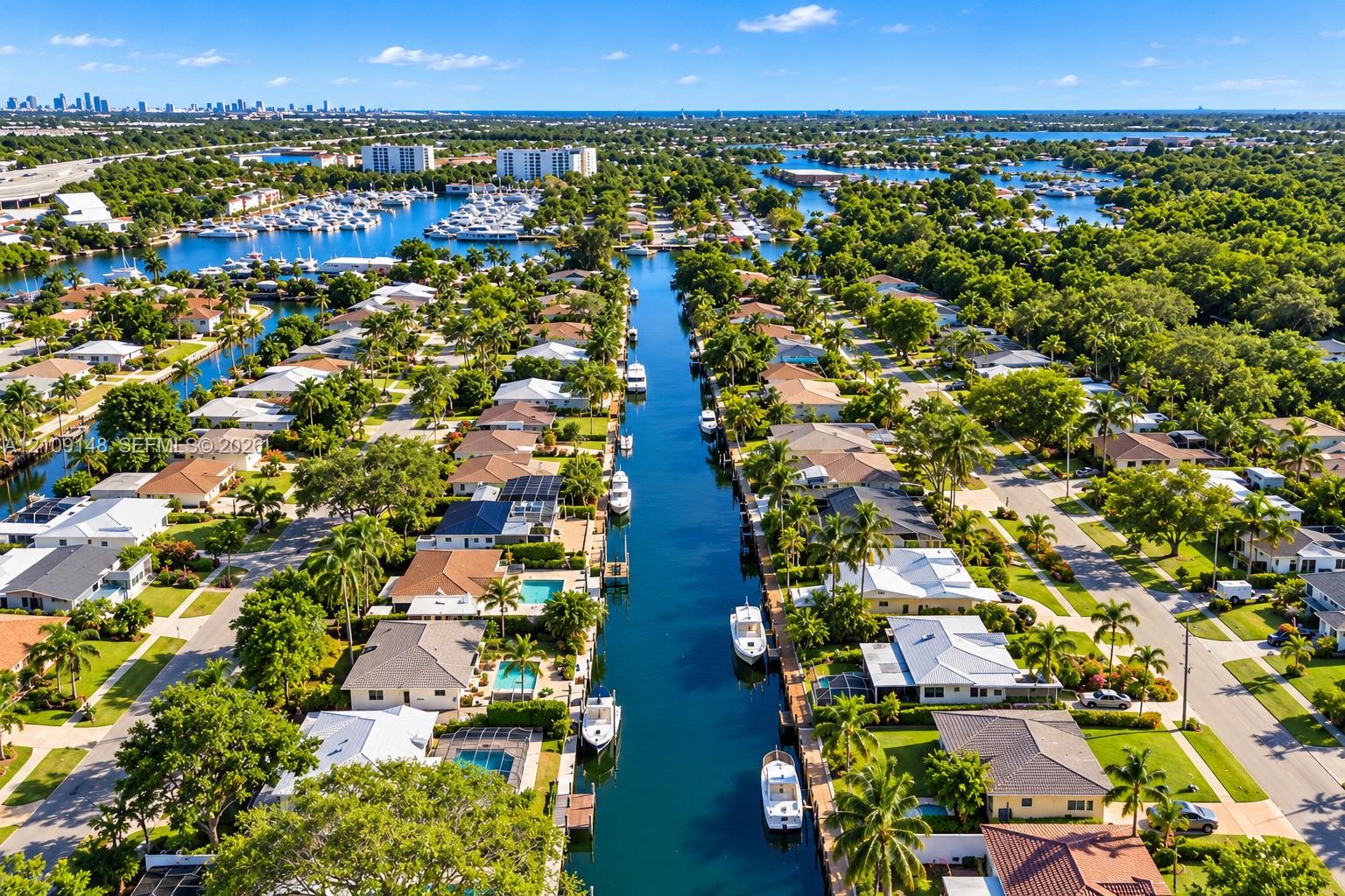 Aerial perspective of a waterfront residential neighborhood featuring deep-water canal access, private boat docks, and established coastal landscaping