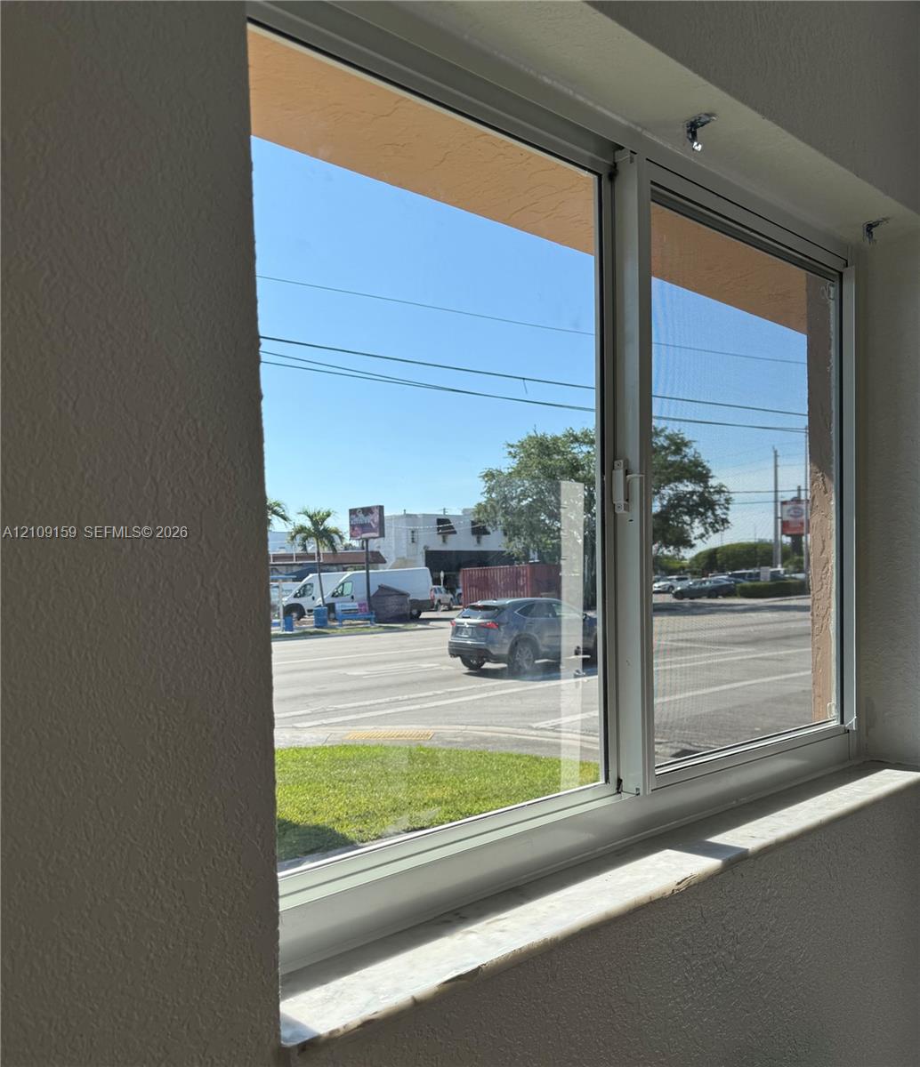 Horizontal sliding window featuring a white frame, integrated screen, and a stone-finish sill