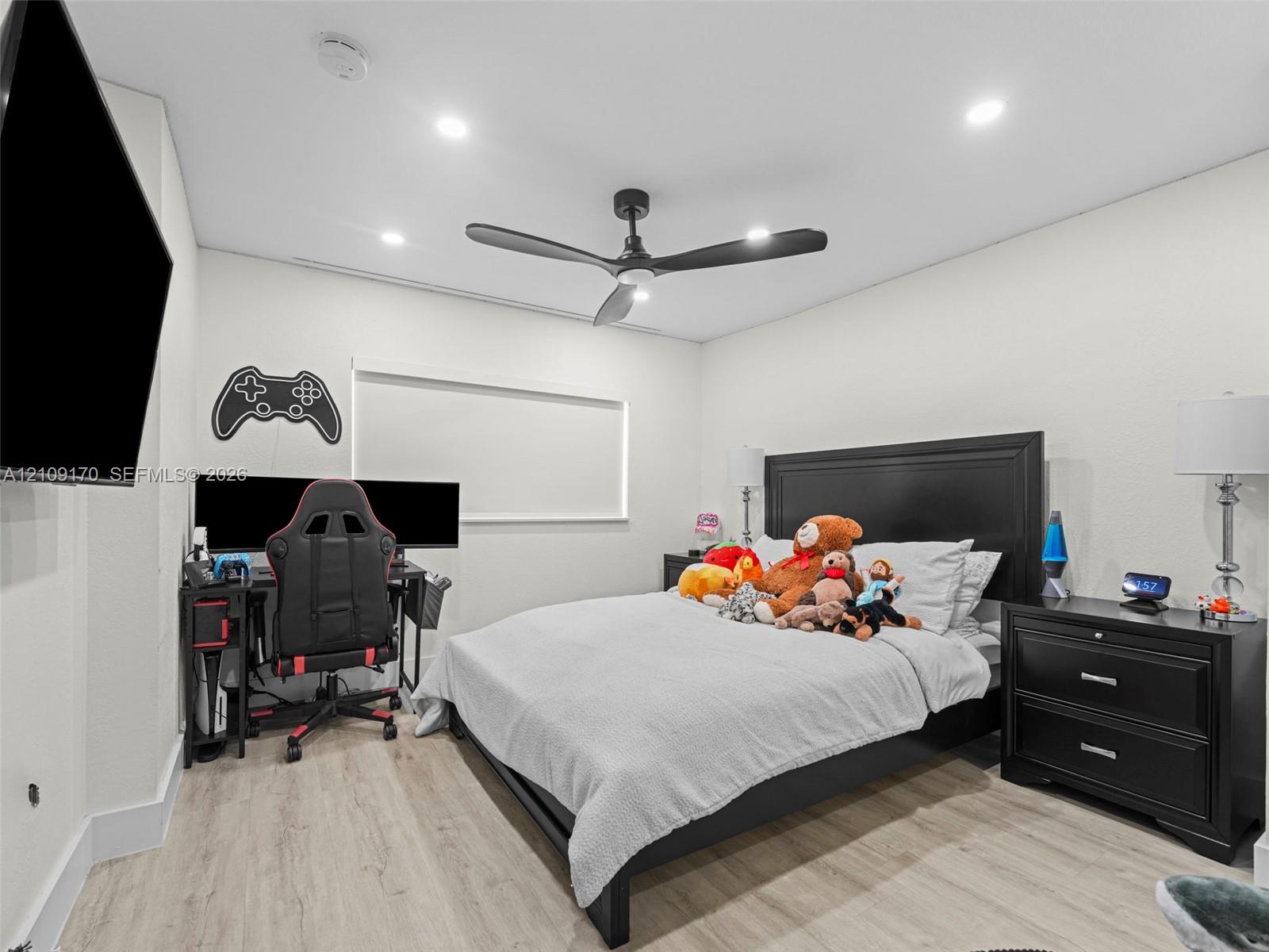 Room featuring wood-finish flooring, recessed lighting, and a modern ceiling fan with matte black blades