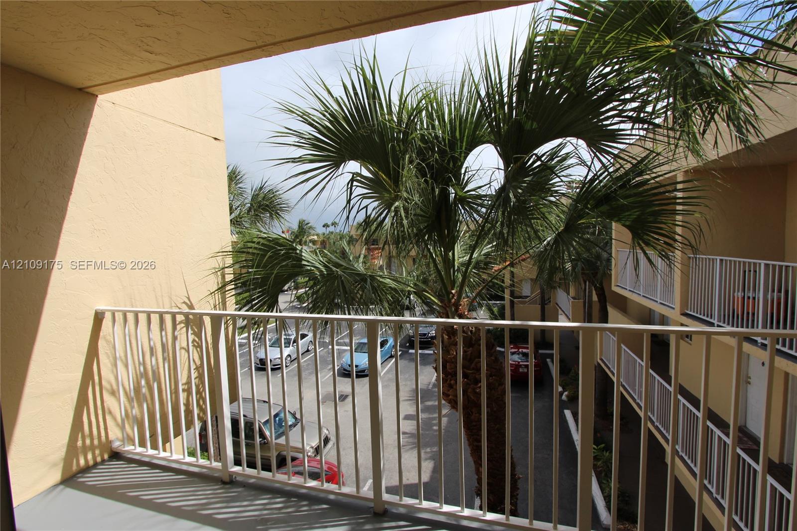 Covered balcony featuring a solid surface floor and a metal railing