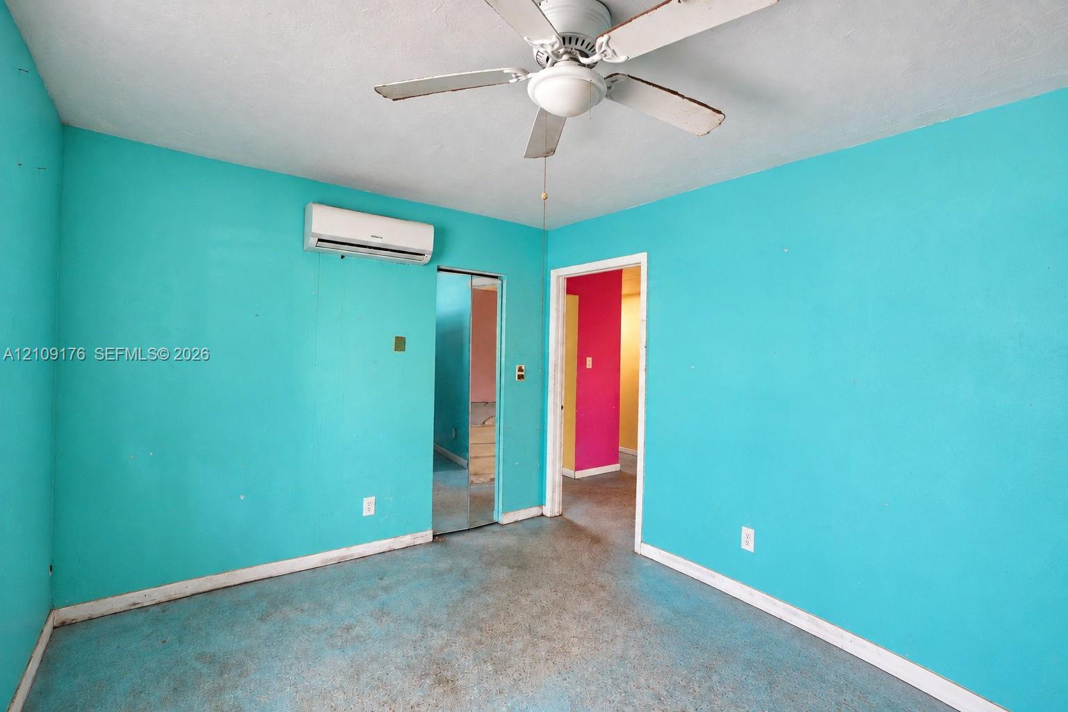 Wall-mounted ductless air conditioning unit, ceiling fan with integrated lighting, and mirrored closet doors