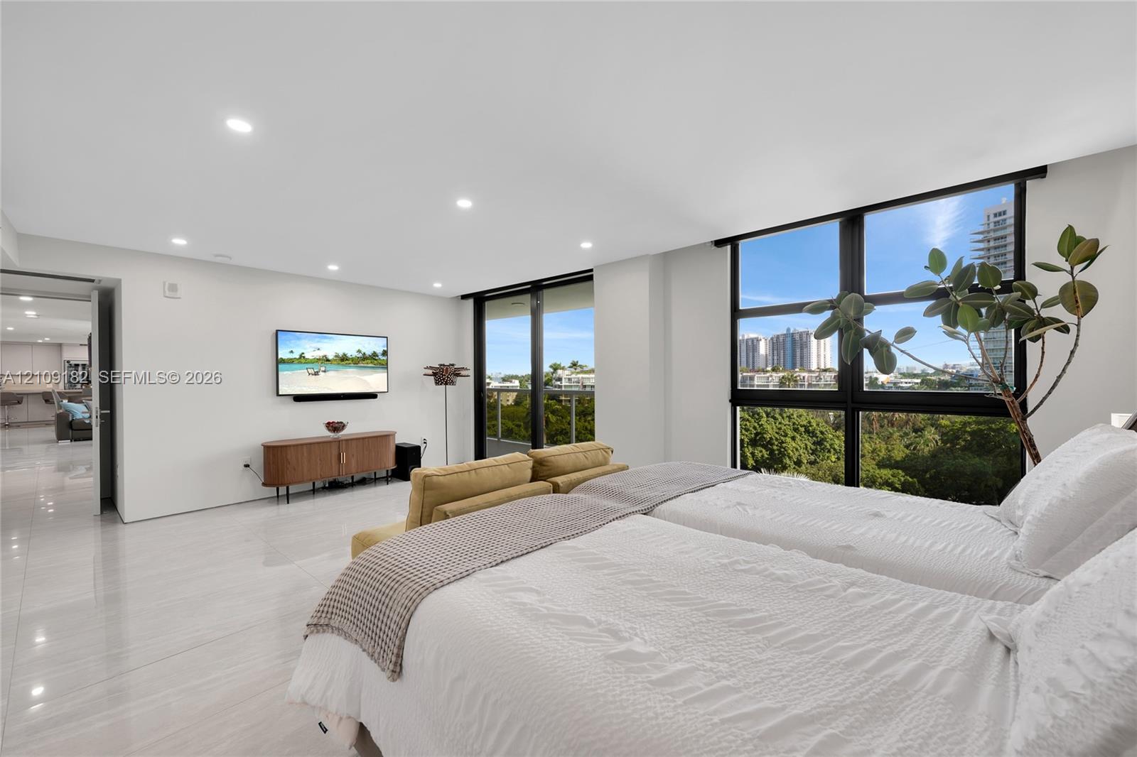 Spacious room featuring polished tile flooring, recessed lighting, and floor-to-ceiling windows with dark-finish framing