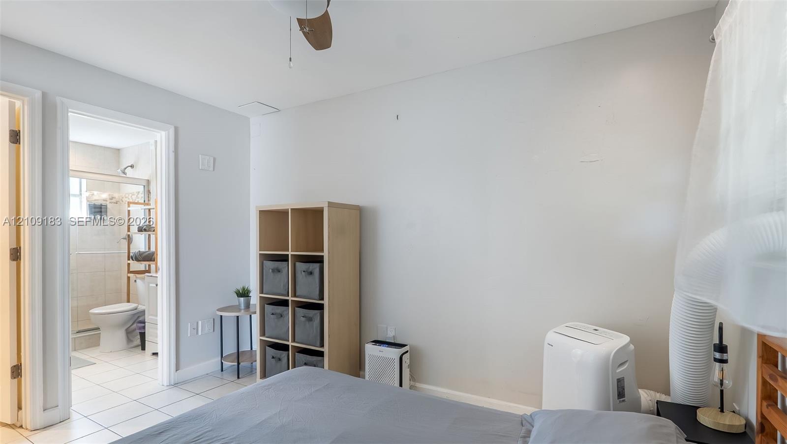 Room featuring a ceiling fan, light-colored neutral wall paint, and ceramic tile flooring throughout the interior space