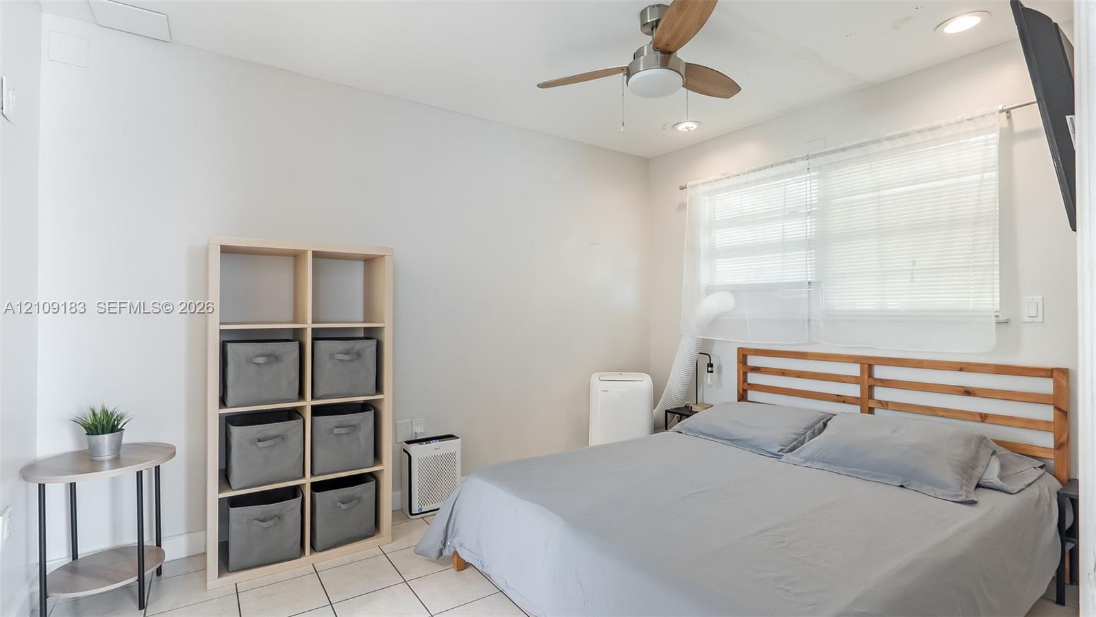 Neutral-toned walls paired with large-format floor tile, recessed lighting, and a modern ceiling fan with wood-finish blades