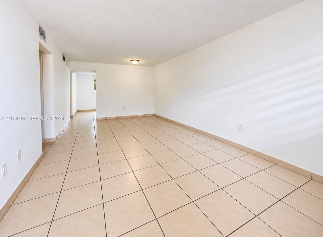 Neutral-toned ceramic tile flooring, smooth wall finishes, and flush-mount ceiling lighting