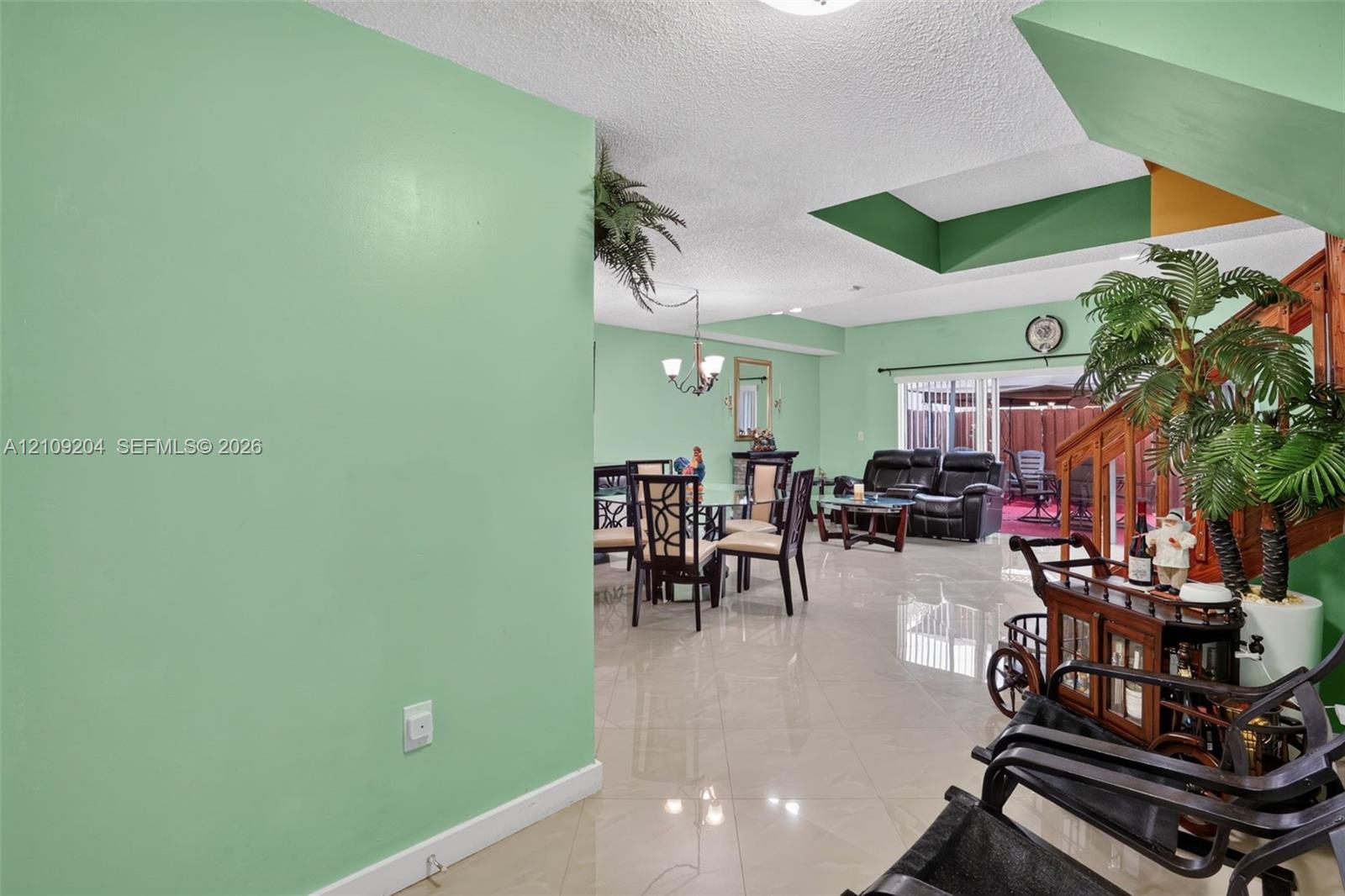 Large-format tile flooring, recessed ceiling alcove, and sliding glass doors with direct exterior access Large-format tile flooring, recessed ceiling alcove, and sliding glass doors with direct exterior access