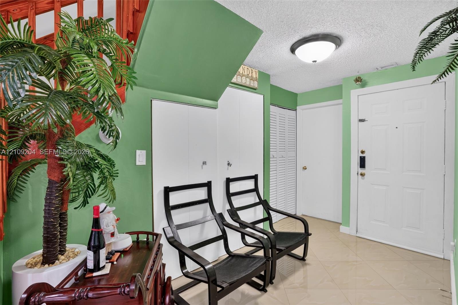Entryway featuring tiled flooring, flush-mount ceiling lighting, white paneled doors, and louvered closet doors Entryway featuring tiled flooring, flush-mount ceiling lighting, white paneled doors, and louvered closet doors