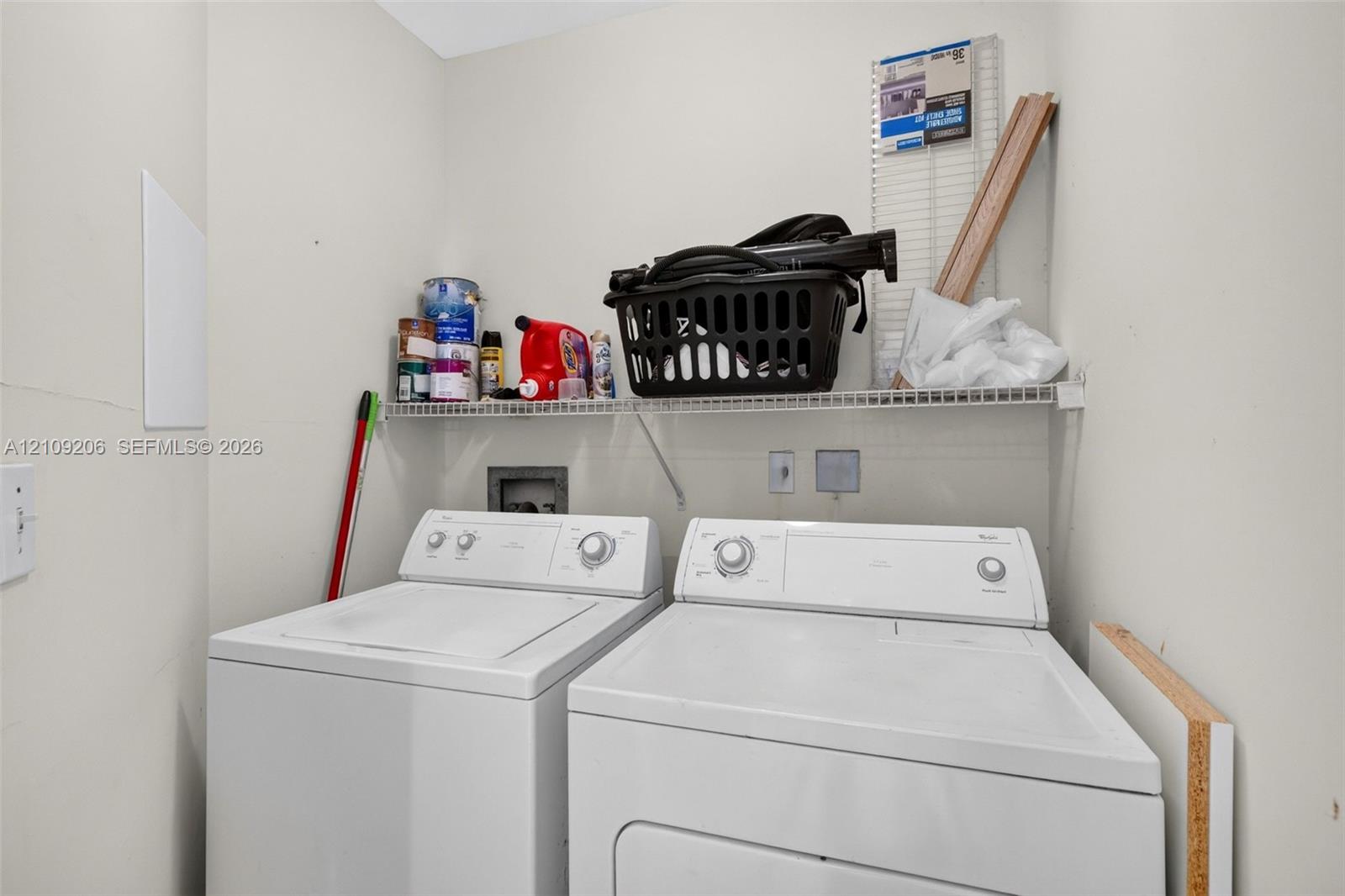 Dedicated laundry area featuring a white wire shelving unit and hookups for appliances