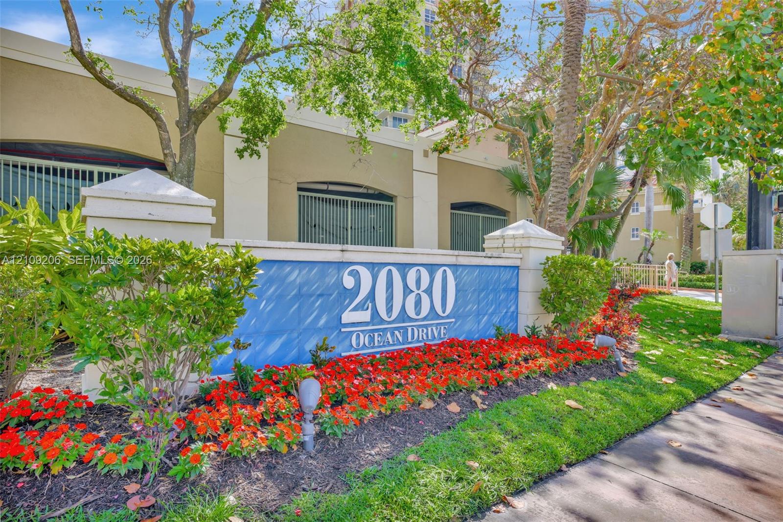 Exterior monument signage featuring raised address lettering, concrete masonry construction, manicured landscaping, and low-voltage landscape lighting