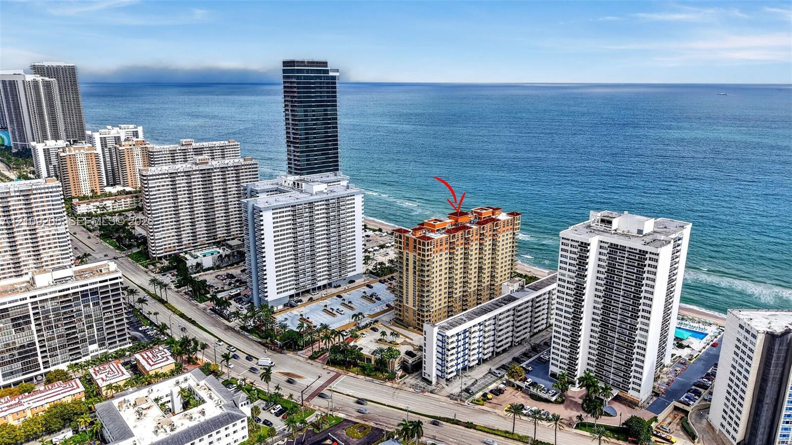 High-rise residential building featuring a terracotta-tiled roof and immediate coastal proximity to the Atlantic Ocean