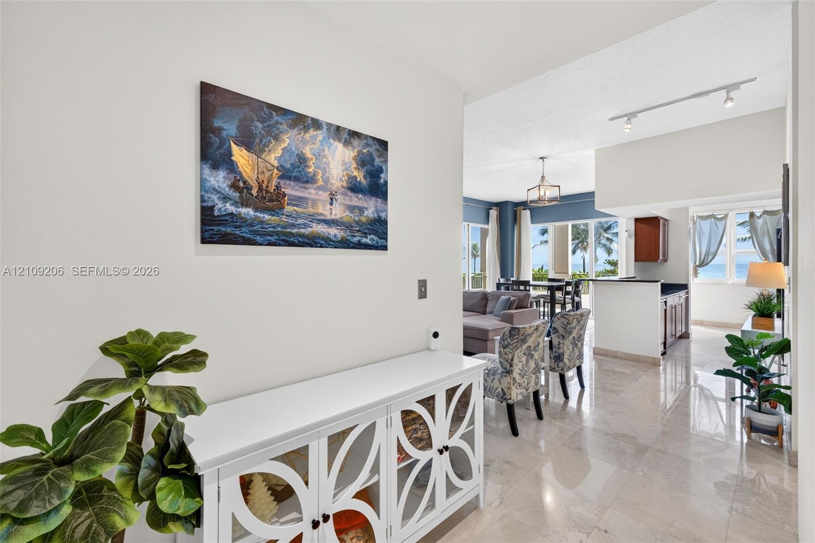 Interior featuring polished stone flooring, recessed track lighting, and a multi-light chandelier