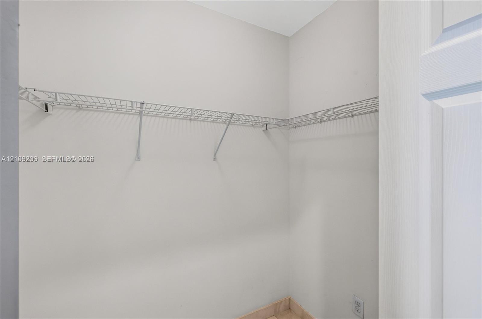 Storage space featuring wall-mounted wire shelving and neutral painted walls