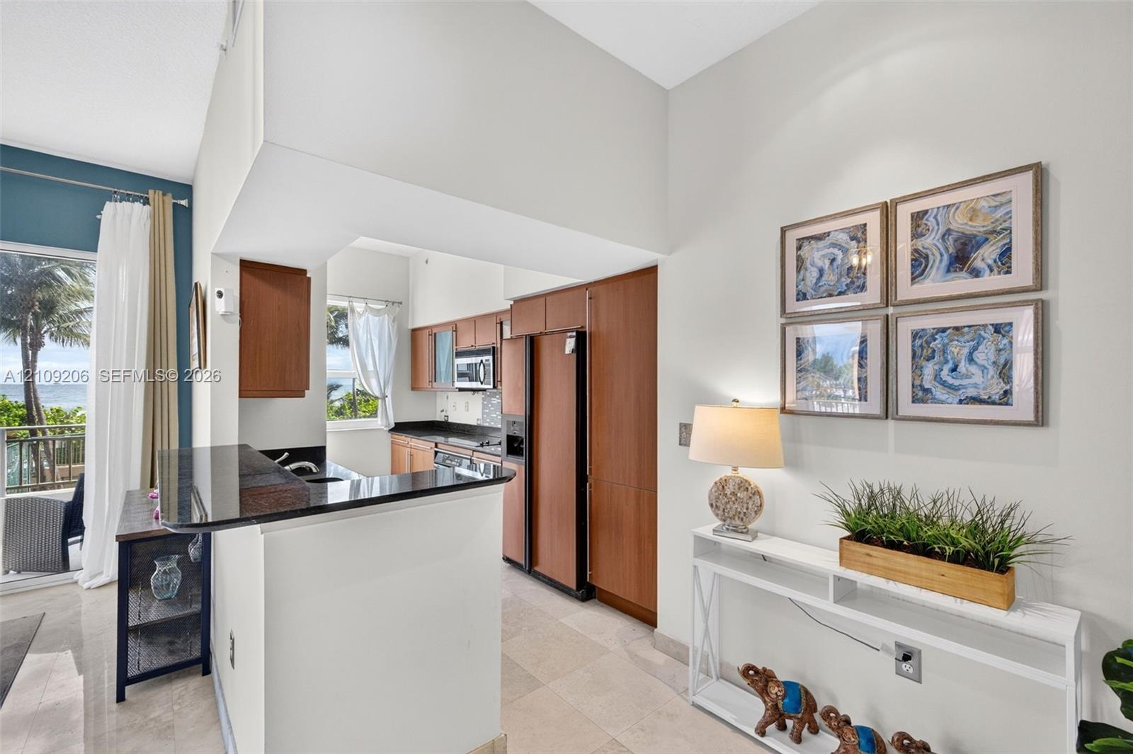 Kitchen featuring wood-finish cabinetry, stone countertops, a breakfast bar, and tile flooring