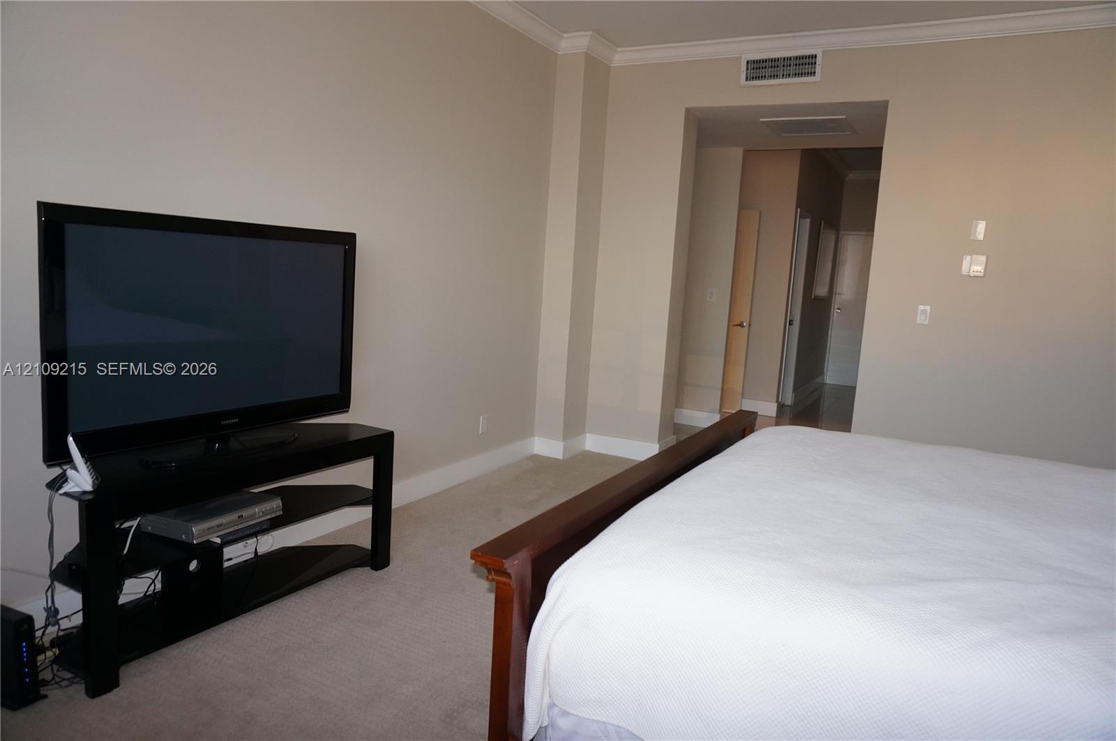 Neutral wall tones, carpeting, and crown molding