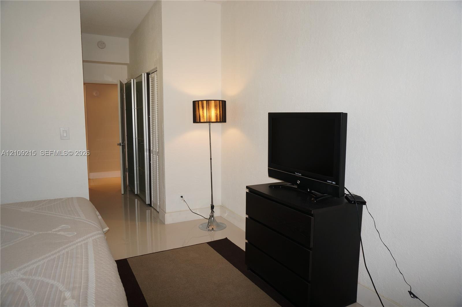 Glossy tile flooring and bi-fold closet doors with white frames