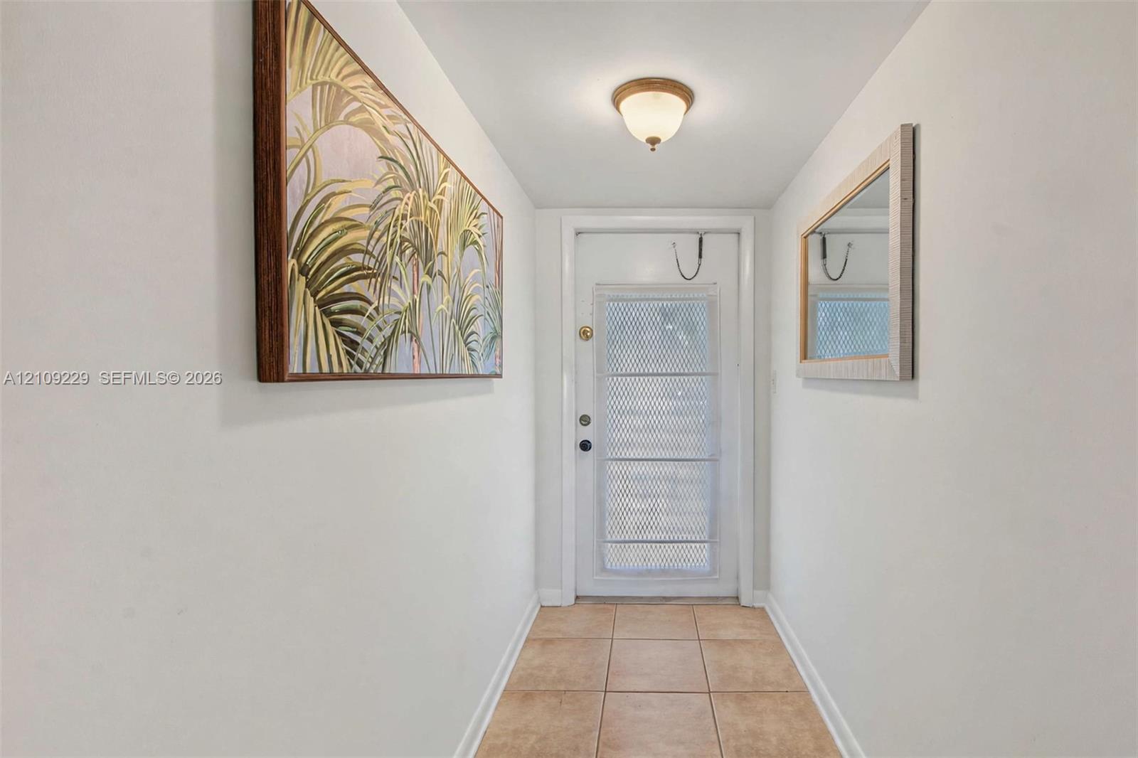 Entryway featuring ceramic tile flooring, a white-framed glass-panel door with metal storm gate, and a flush-mount dome ceiling light fixture Entryway featuring ceramic tile flooring, a white-framed glass-panel door with metal storm gate, and a flush-mount dome ceiling light fixture