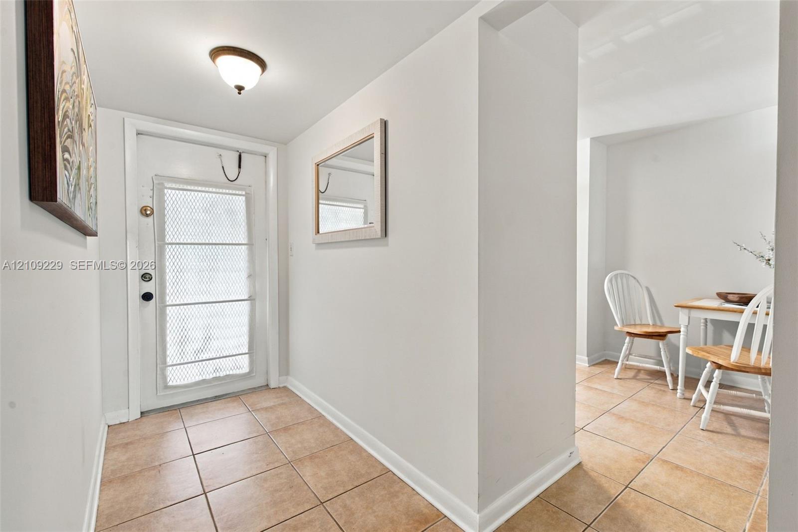 Entryway featuring ceramic tile flooring, a white exterior door with glass inlay, and a flush-mount ceiling fixture Entryway featuring ceramic tile flooring, a white exterior door with glass inlay, and a flush-mount ceiling fixture