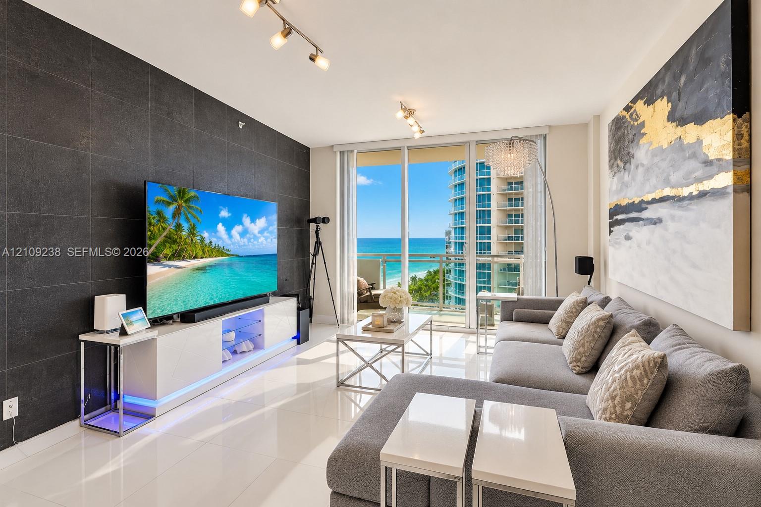Living area featuring a large format dark tile accent wall, polished tile flooring, glass sliding doors, and adjustable track lighting