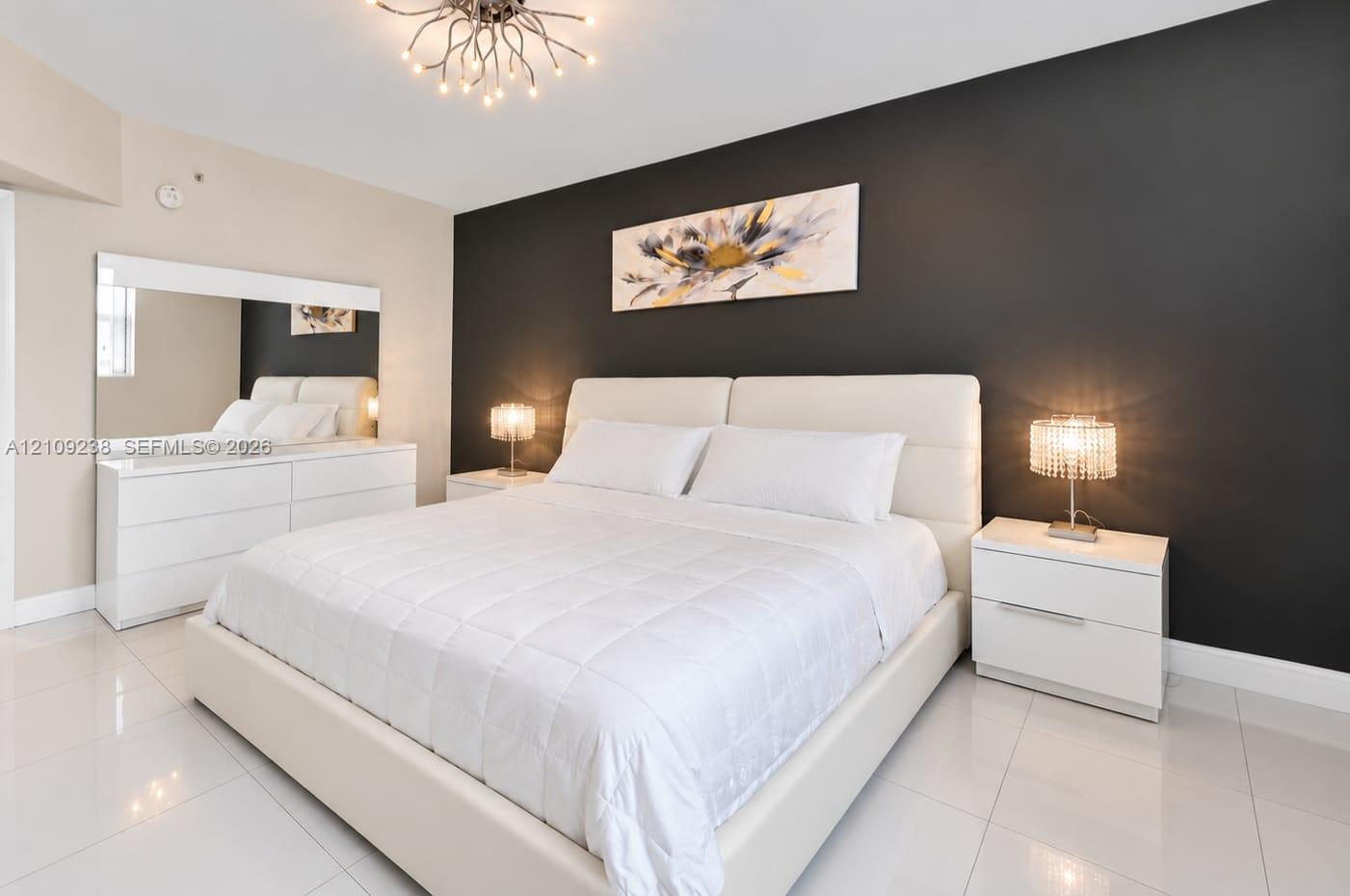Polished tile flooring, contrast charcoal accent wall, and geometric branch-style chandelier