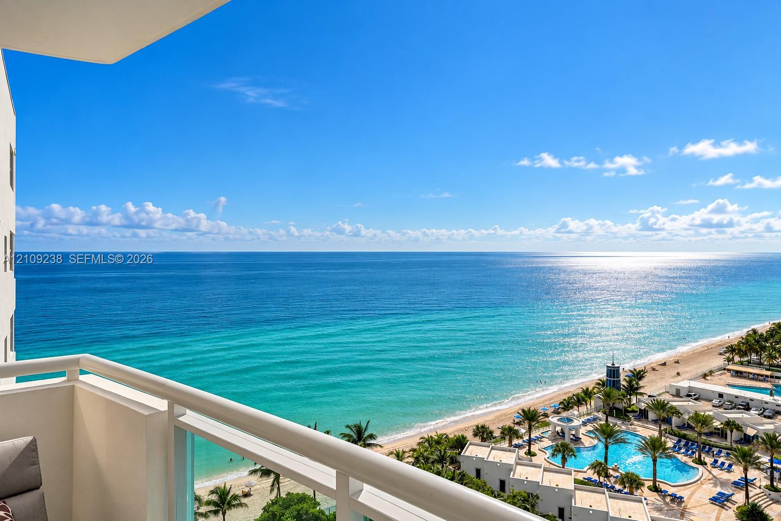 Private balcony featuring a white metal railing and expansive ocean backdrop