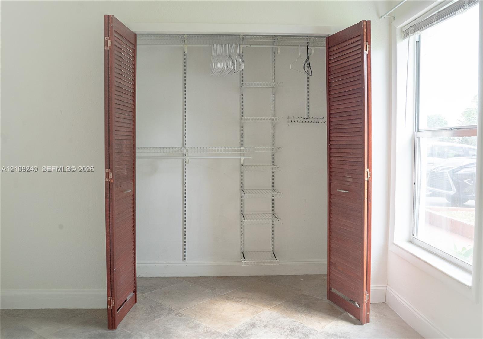 Closet featuring bi-fold louvered wood doors and a white wire shelving system