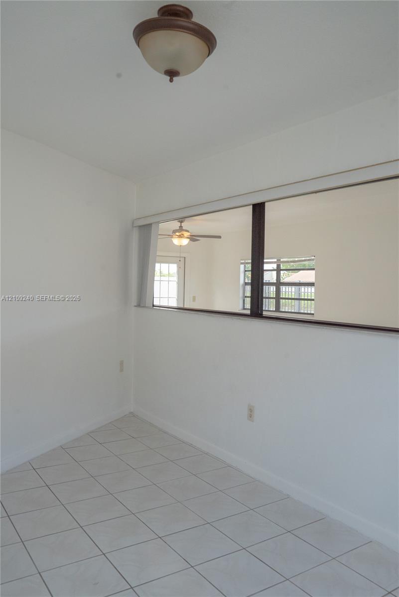 White ceramic tile flooring, semi-flush mount dome ceiling fixture, and interior rectangular wall cutout