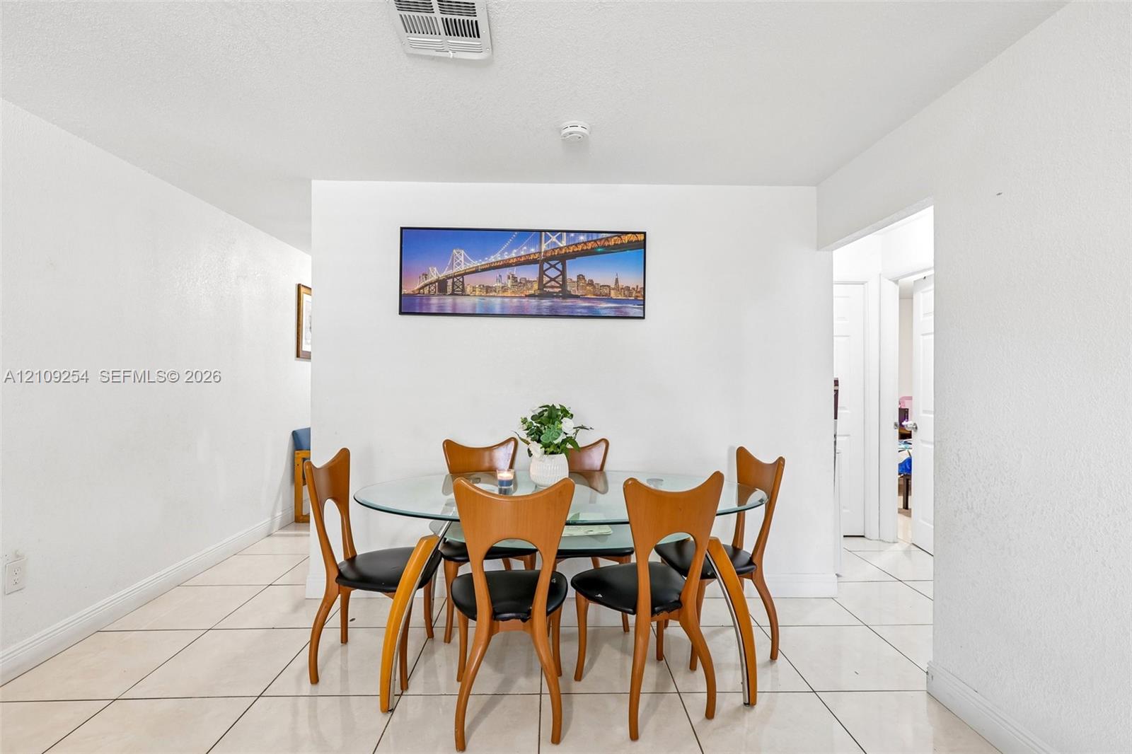 Large-format ceramic floor tiling throughout the space, punctuated by smooth wall surfaces and recessed ceiling lighting