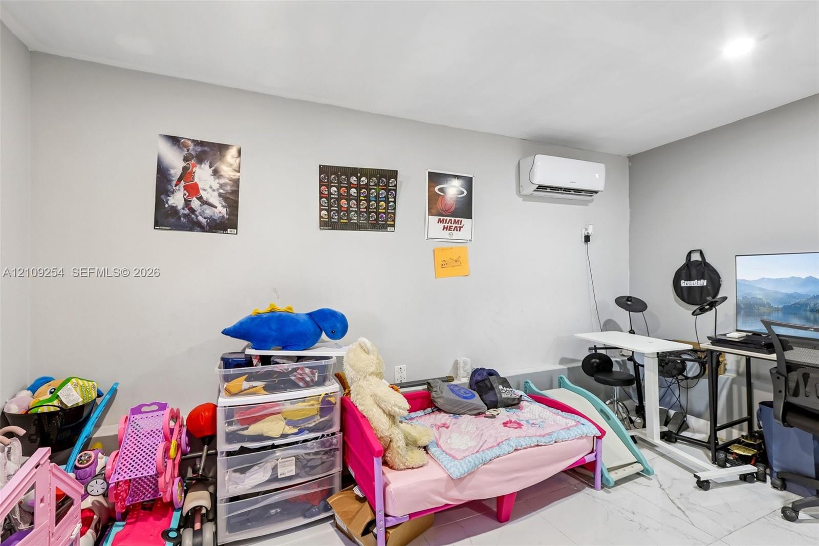Interior room featuring neutral wall paint, polished tile flooring, and a wall-mounted ductless air conditioning unit
