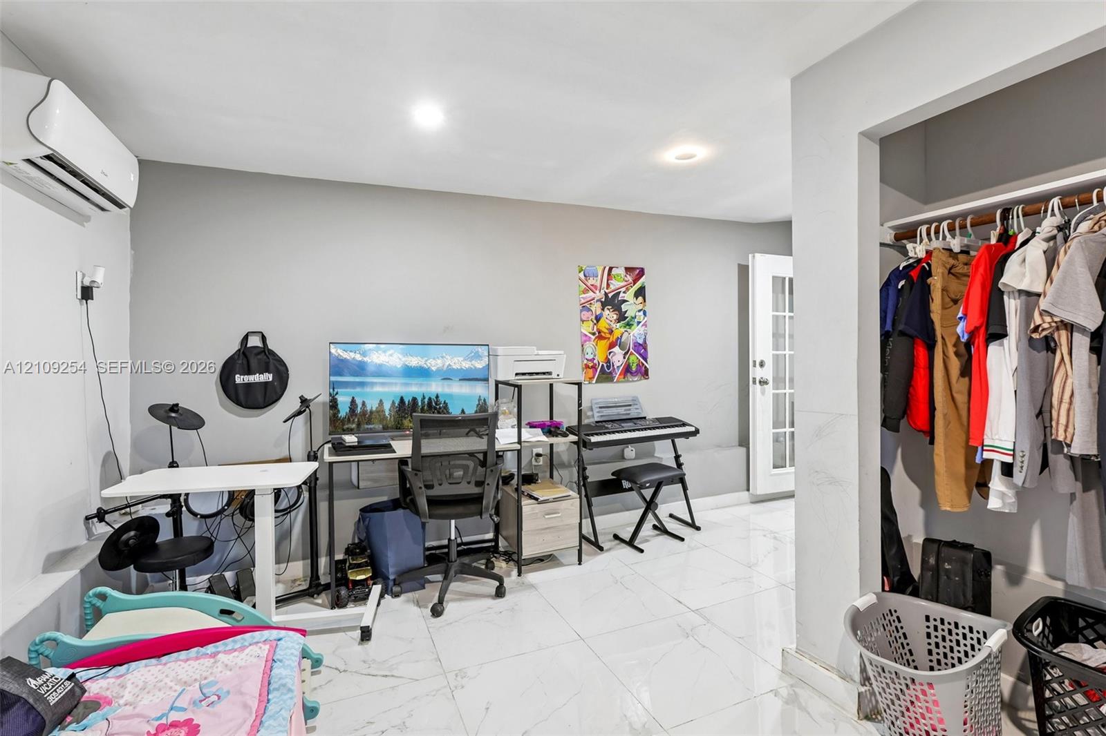 Interior room featuring polished tile flooring, wall-mounted climate control unit, recessed lighting, and a reach-in closet with built-in shelving